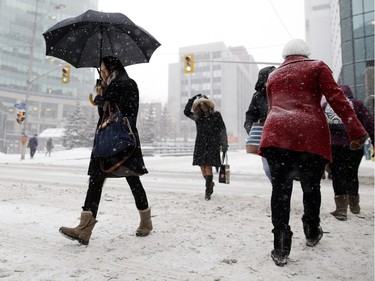 People commute through downtown Ottawa during a winter storm Tuesday February 16, 2016.