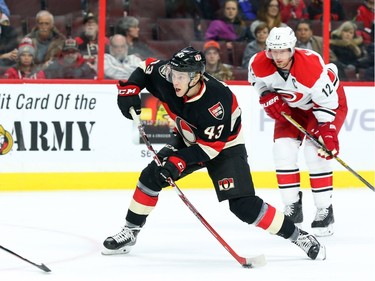 Ryan Dzingel of the Ottawa Senators shoots as he is defended by Eric Staal of the Carolina Hurricanes during first period NHL action.