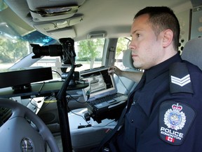 A police officer shows off a Community Safe Speed photo radar van during the unveiling of the vans in Edmonton in 2009.