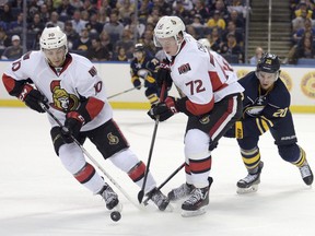 Jason Akeson, while with the Buffalo Sabres in training camp, battles against the Ottawa Senators' Shane Price (10) and Thomas Chabot during preseason action.