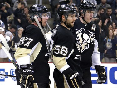 Pittsburgh Penguins' Sidney Crosby (87) celebrates a second-period goal with teammates Evgeni Malkin (71) and Kris Letang (58).