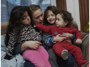 Host family member Kai,16, with Syrian refugees Zahraa, 7, Hala, 5, and Saleh, 14 months.