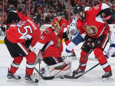 Craig Anderson #41 of the Ottawa Senators makes a save against the Tampa Bay Lightning as Chris Wideman #45 and Mika Zibanejad #93 cover the rebound.