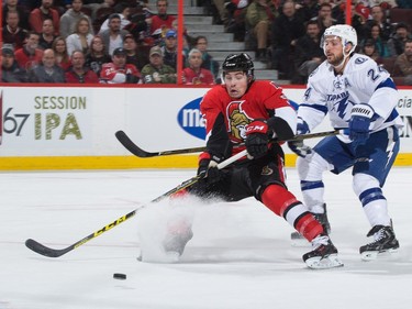 Ryan Callahan #24 of the Tampa Bay Lightning hooks Cody Ceci #5 of the Ottawa Senators off a scoring chance, resulting in a penalty during first period action.