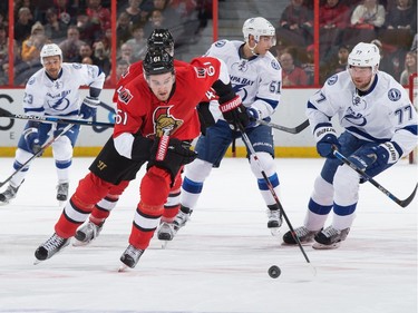 Mark Stone #61 of the Ottawa Senators skates up ice with the puck against Victor Hedman #77 of the Tampa Bay Lightning.