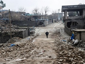 A man walks along a road damaged in the fighting between government troops and separatist Kurdistan Workers' Party (PKK) fighters, in the Kurdish town of Silopi, in southeastern Turkey, near the border with Iraq on January 19, 2016.  Turkey is waging an all-out offensive against the separatist Kurdistan Workers' Party (PKK), with military operations backed by curfews aimed at flushing out rebels from several southeastern urban centres.  / AFP / ILYAS AKENGINILYAS AKENGIN/AFP/Getty Images