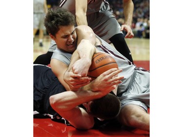 uOttawa Gee-Gees' Brody Maracle, top, wrestles for the ball against Carleton University Ravens' Mitchell Wood.