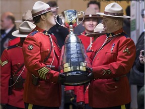 One of the RCMP officers kisses the cup as he prepares to walk it onto the field at the beginning of the 103rd Grey Cup between the Edmonton Eskimos and the Ottawa Redblacks.
