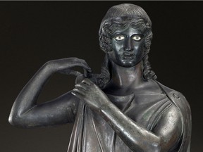 A bronze of a woman fastening her clothing. From Herculaneum.
