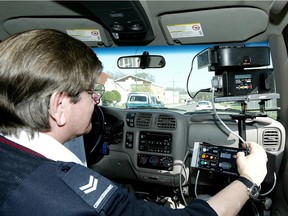 A mobile photo radar operator calibrates a camera unit while waiting for speeders on Mountain Avenue in Winnipeg. Will Ottawa bring photo radar to city streets?