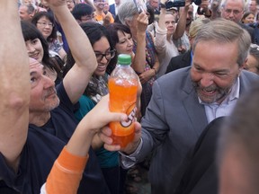 A supporter hands NDP Leader Tom Mulcair a bottle of Orange Crush during a campaign rally in Vancouver on Aug. 9, 2015, early in the election campaign.