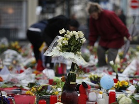 Women tend to the tributes left for the victims of the recent bomb attacks in Brussels, at Place de la Bourse, on Monday.