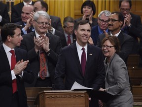 Public Services and Procurement Judy Foote jokes with Minister of Finance Bill Morneau as he delivers the federal budget in the House of Commons on Parliament Hill in Ottawa on Tuesday, March 22, 2016.