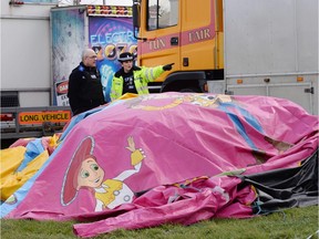 Police and forensic officers attend the scene Sunday, March 27, 2016, where a seven-year old girl died after she was blown by the wind about 150 metres on a bouncy castle on Saturday. The children's bouncy castle is thought to have been swept away by a gust of wind as families gathered for an Easter fair, over the long holiday weekend.