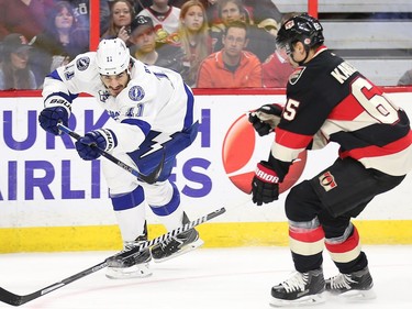 Brian Boyle shoots the puck past Erik Karlsson in the second period as the Ottawa Senators take on the Tampa Bay Lightning in NHL action at the Canadian Tire Centre in Ottawa.