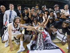 The Carleton Ravens pose with the W. P. McGee Trophy after defeating the University of Calgary Dinos to win the CIS men's national university basketball championship final in Vancouver on Sunday, March 20, 2016.