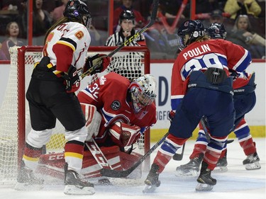 Les Canadiennes de Montreal goaltender Charline Labonte (32) makes a stop as teammate Marie-Philip Poulin (29) and Calgary Inferno Carly Hill (6) look on during the second period of Canadian Women's Hockey League final action at the Clarkson Cup, Sunday March 13, 2016, in Ottawa.