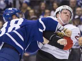 The Toronto Maple Leafs' Colin Greening and the Ottawa Senators' Dion Phaneuf scrap in the former Leafs captain's first game back in Toronto since a February trade  that also involved Greening.