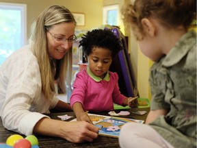 Daycare owner, Cindy Chouinard, left, assembles a puzzle with Kaliopi, center, while Raheema, right, looks on at her licensed home daycare she's been operating for over 20 years Friday September 25, 2015. (Darren Brown/Ottawa Citizen)