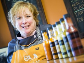 Donna Chevrier, owner of Ola Cocina, poses with some of her very hot, hot sauces in her taco restaurant, Ola Cocina