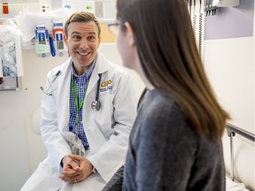 Dr. Roger Zemek, left, talks with former patient, Jenna Pietrantonio, in an examination room at the Children's Hospital of Eastern Ontario.