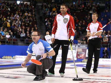 Eric Sylvain, second of Team Quebec, yells after his rock  as John Morris (M) and Carter Rycroft of Team Canada look on at the Tim Hortons Brier at TD Place in Ottawa, March 05, 2016.