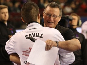 Event MC Stuart Brown shares a hug with Craig Savill during the Tim Hortons Brier held at TD Place in Ottawa, March 10, 2016.