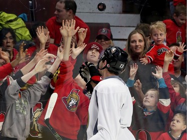 Young fans reach for a puck tossed into the stands by Nick Paul.