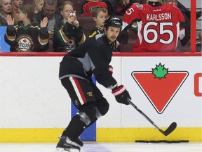 Erik Karlsson looks for the puck, apparently oblivious to the nearby presence of admirers.