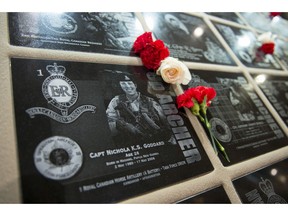 Flowers adorn a plaque dedicated to Capt. Nichola Goddard, the first female Canadian Forces member killed in Afghanistan, as part of the Afghanistan Memorial Vigil in the Hall of Honour in Parliament Hill's Centre Block during the National Day of Honour in Ottawa on Friday, May 9, 2014. Ottawa hosts a national day of commemoration for the soldiers who participated in the war in Afghanistan; 190 plaques from Kandahar Air Field are displayed in the Vigil, representing those killed during Canada's military engagement in Afghanistan.
