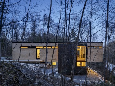 This Gatineau Hills cottage sits cantilevered atop a cliff with a view of a lake. The floor-to-ceiling windows provide a commanding view of everything from the water to the treetops. 'Living in the woods is amazing,' says architect Chris Simmonds of his winning design. 'Every week things look different — the snow blowing, the animal tracks, the trilliums coming through.'
