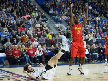 Calgary Dinos' David Kapinga, right, reacts after being called for charging against Carleton Ravens' Gavin Resch, left, during CIS men's national university basketball championship final game action in Vancouver, B.C., on Sunday March 20, 2016.