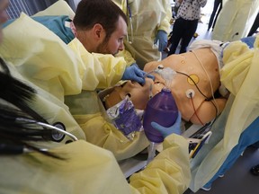 In this Tuesday, Feb. 11, 2014 photo, surgical residents along surgical residents among with experienced surgeons train on a mannequin at the Surgical Simulation and Training Laboratory in the Department of Surgery at Cedars-Sinai Medical Center in Los Angeles. The operating room of the future is being tested in an ongoing experiment aimed at breaking down barriers that bog down care through open communication and better use of technology.