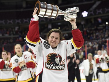 Calgary Inferno Jenna Cunningham (14) lifts the Clarkson Cup trophy after winning against Les Canadiennes de Montreal in Canadian Women's Hockey League final action, Sunday March 13, 2016, in Ottawa.