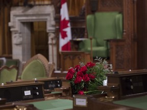 Flowers sit on the desk of MP Jim Hillyer in the House of Commons on Wednesday March 23, 2016. Hiller passed away at the age of 41 in his office.