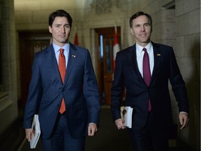 Minister of Finance Bill Morneau is accompanied by Prime Minister Justin Trudeau as he makes his way to deliver the federal budget in the House of Commons on Parliament Hill in Ottawa on Tuesday, March 22, 2016.