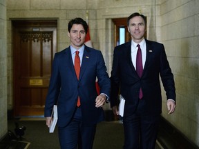 Minister of Finance Bill Morneau, right, is accompanied by Prime Minister Justin Trudeau as he makes his way to deliver the federal budget in the House of Commons on Tuesday, March 22, 2016.