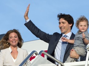 Prime Minister Justin Trudeau, holding his son Hadrian, waves as he steps off the plane with his wife Sophie Gregoire-Trudeau during a welcome ceremony at Andrews Air Force Base, Md., Wednesday, March 9, 2016.