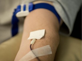 A blood donor has blood taken from him at the Ottawa Blood Services clinic in Ottawa, July 9, 2013