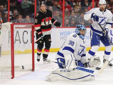 Mark Stone (L) looks on as goalie Ben Bishop blocks a shot with defenseman Braydon Coburn (R) defending in the first period as the Ottawa Senators take on the Tampa Bay Lightning in NHL action at the Canadian Tire Centre in Ottawa.