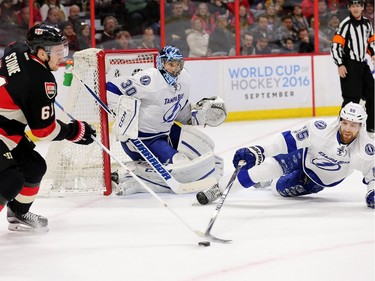 Mark Stone (L) tries a shot as goalie Ben Bishop gets into position with defenseman Braydon Coburn (R) defending in the first period as the Ottawa Senators take on the Tampa Bay Lightning in NHL action at the Canadian Tire Centre in Ottawa.