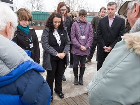 Members of the Pine Grove Bible Church in Beacon Hill say prayers with Councillor Tim Tierney, right, during a morning vigil at the corner of Ogilvie Road and Jasmine Crescent, near the spot where a young man was gunned down on Tuesday evening.