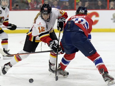 Calgary Inferno's Meaghan Mikkelson-Reid (12) battles for possession with Les Canadiennes de Montreal Jordanna Peroff (20) during first period of Canadian Women's Hockey League final action at the Clarkson Cup, Sunday March 13, 2016, in Ottawa.