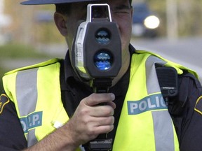 An OPP constable uses a laser radar unit on a provincial highway.
