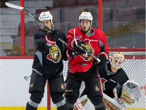 Ottawa Senator defenceman Erik Karlsson (L) checks Mika Zibanejad in front of net minder Andrew Hammond during team practice at the Canadian Tire Centre on Tuesday March 29, 2016. Errol McGihon