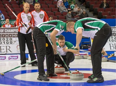 Pat Simmons and John Morris of Team Canada watch as Team Saskatchewan's Dallan Muyres, Kirk Muyres and Colton Flasch sweep their rock as the Tim Horton's Brier continues on Sunday at TD Place in Ottawa.