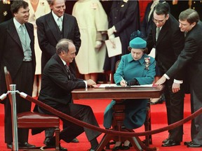 The Queen signs Canada's constitutional proclamation in Ottawa on April 17, 1982 as Prime Minister Pierre Trudeau looks on.
