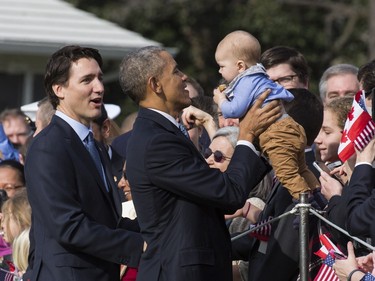WASHINGTON, DC - MARCH 10:  U.S. President Barack Obama holds a baby as Canadian Prime Minister Justin Trudeau looks on during an arrival ceremony on the South Lawn of the White House, March 10, 2016 in Washington, DC. This is Trudeau's first trip to Washington since becoming Prime Minister.