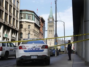 Police investigate a scene on Metcalfe Street near the Parliament Buildings where an RCMP officer died of a self-inflicted gunshot on Thursday, March 17, 2016.