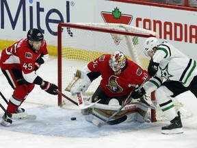 The Dallas Stars' Jason Spezza attempts a wraparound shot as Ottawa Senators goalie Andrew Hammond and Chris Wideman react during the first period.